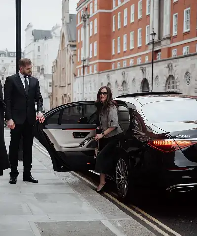 Luxury executive chauffeur vehicle parked near Canary Wharf skyline