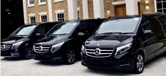 Chauffeur standing beside executive vehicle in London
