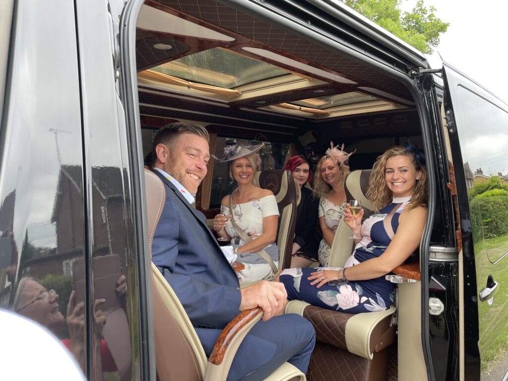 Group boarding a luxury MPV chauffeur vehicle in London