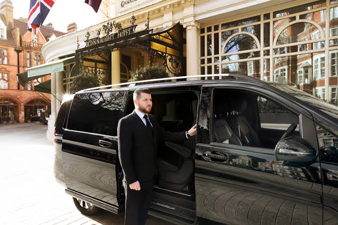 Chauffeur-driven car touring past a London landmark during the day