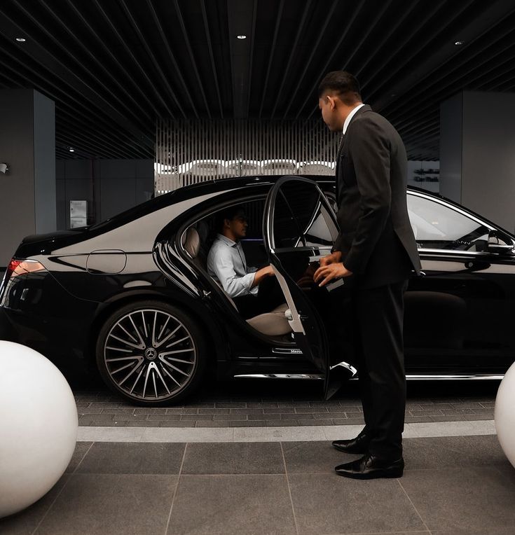 Passenger being greeted by a chauffeur at airport arrivals with luggage