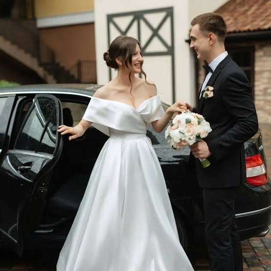 Interior view of a luxury chauffeured vehicle prepared for wedding transportation with champagne and floral touches